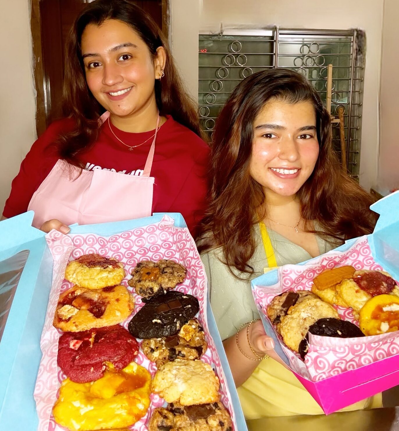 Two people holding open boxes of Sugar Shots cookies